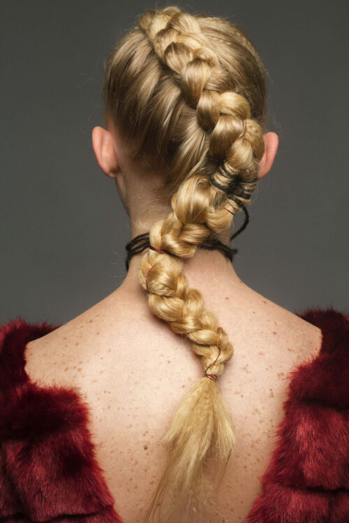 Rückansicht einer Frau mit aufwendig geflochtener Frisur, passend für einen Hairstyling-Workshop.