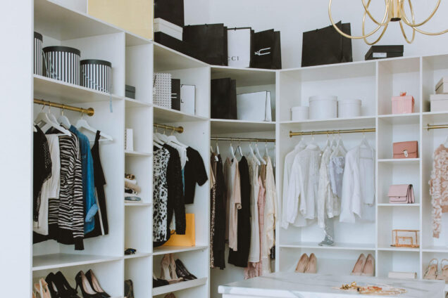 Großer begehbarer Kleiderschrank mit Schubladen, hängender Kleidung und Schuhregalen.