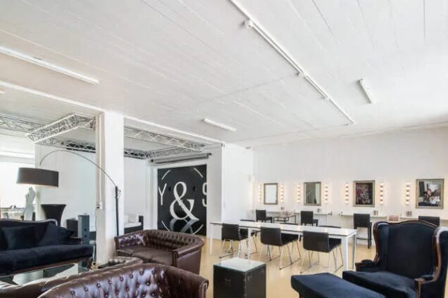 Modern eingerichteter Beauty-Salon mit Ledersofas und Schminktischen in einem hellen, offenen Raum