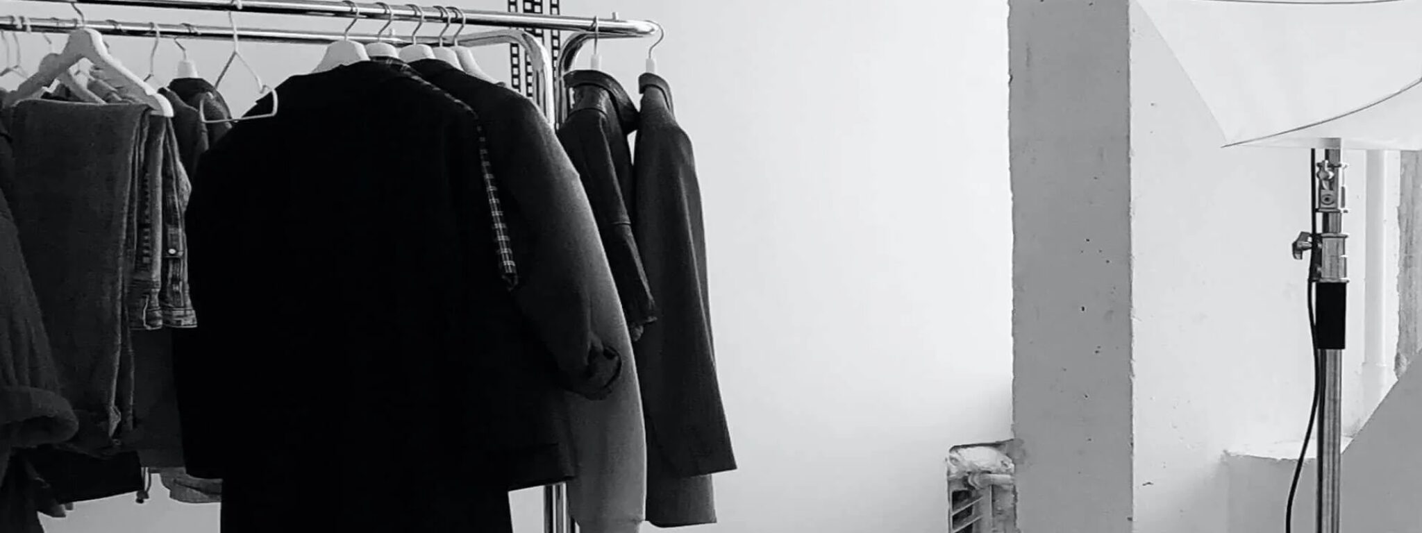 Kleiderständer mit Mänteln und Beleuchtungsausrüstung in einem Studio